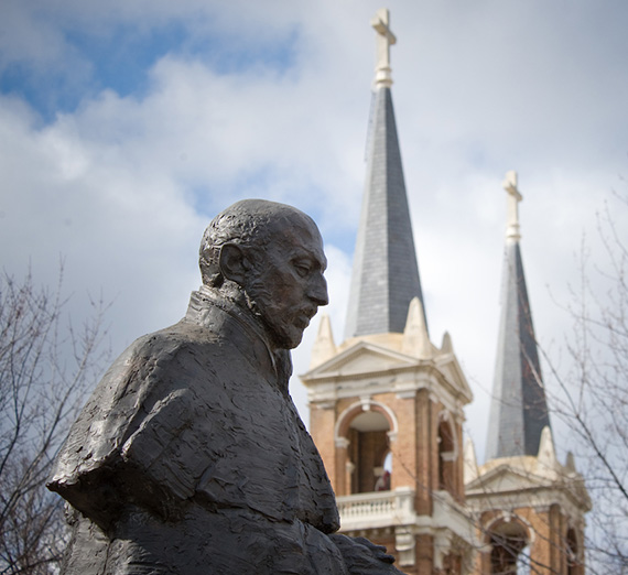 Statue of St. Ignatius Loyola with the spires of St. Aloysius Church nearby