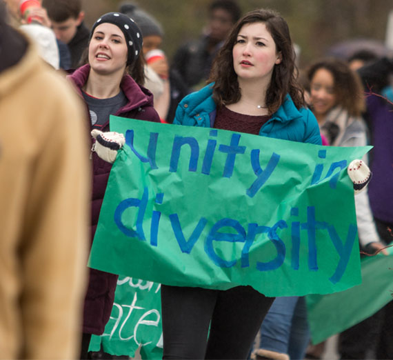 student with sign at diversity march that says "unity in diversity" 