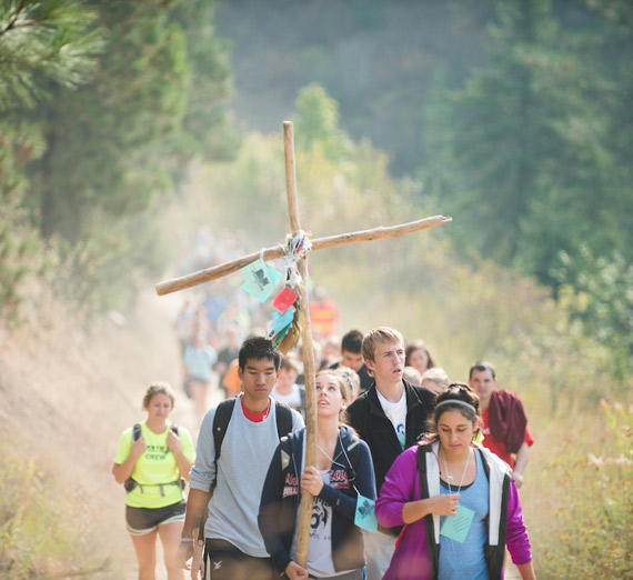 Student walking outdoors with cross
