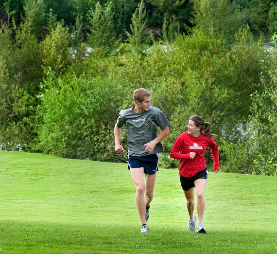 Two students running on campus