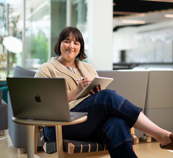 Women smiling sitting at couch on computer