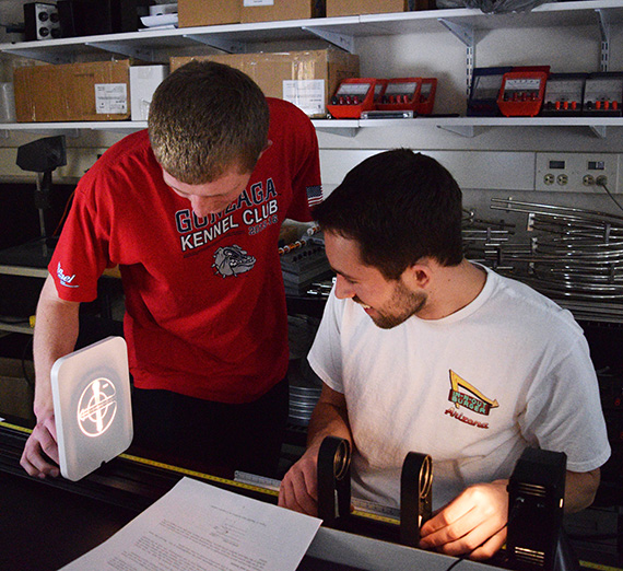 Two physics students filter a beam of light for a project