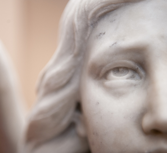 A statue of an angel looks up outside of St. Aloysius.