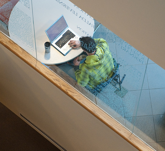 A student studying at a table in the Foley Library