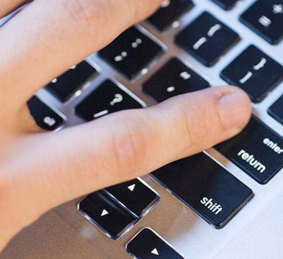 A student typing on a laptop computer.