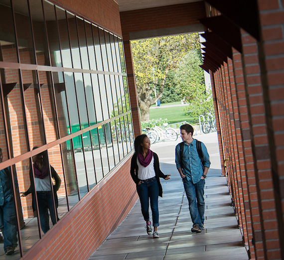 Two students walking next to the Foley Center