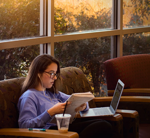 Undergraduate business student studying in Jepson Center lounge
