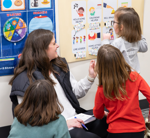 Mother sits with children in preschool