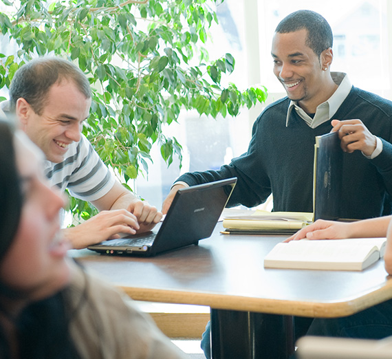 Two students studying together and smiling