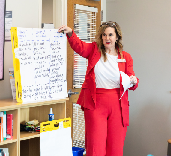 Woman presenting and holding up a paper