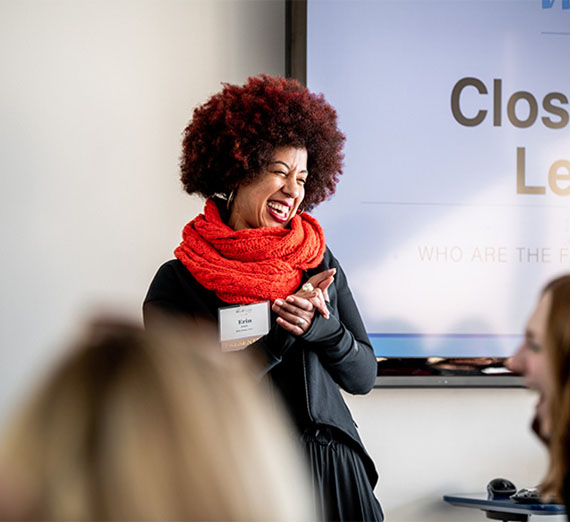 A woman is leading a meeting in a room.