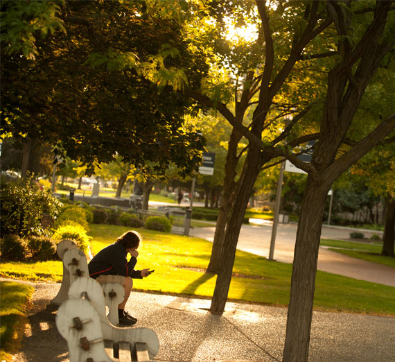 51�Թ� sitting on bench on campus 