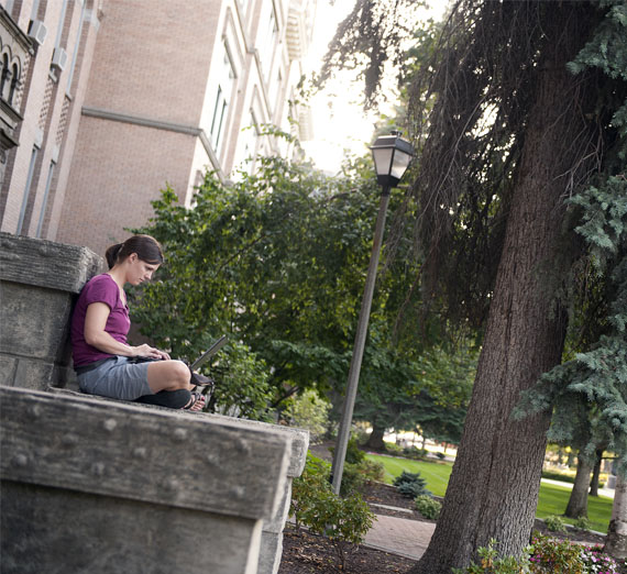 student reading on the steps of college hall 
