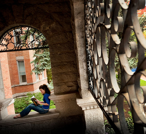 Student reading on front steps of College Hall