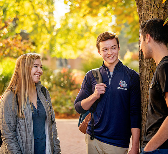 three students talking outside