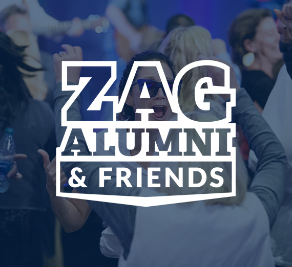 Individuals embracing in the background and the Zag Alumni & Friends logo in the foreground