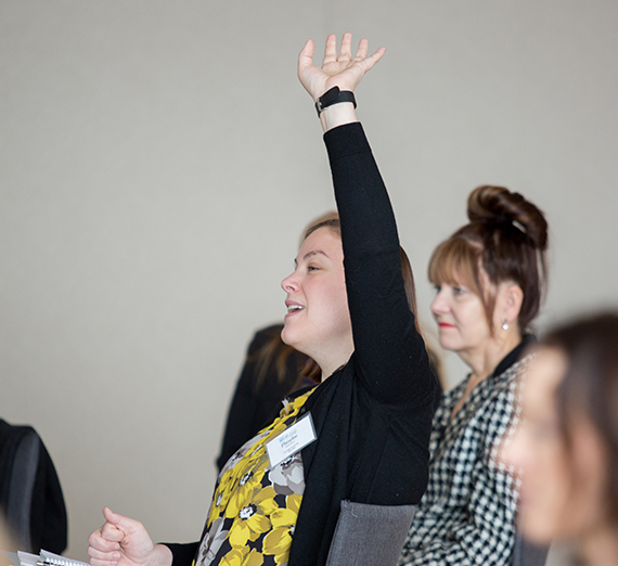 woman raises hand in crowd