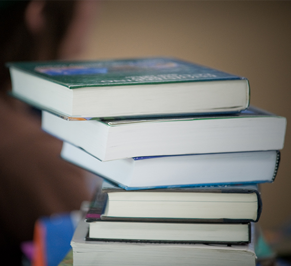 A tall pile of books varying in size