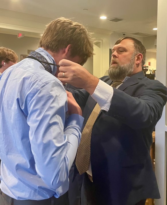 Student getting help tying his tie from a Gonzaga staff member.