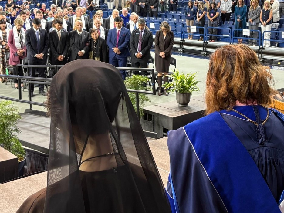 Sister Raffaella Petrini in a black veil, and President Passerini in regalia look onto the inauguration crowd in the McCarthey Athletic Center