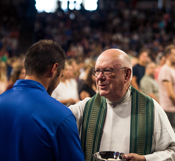 A student receives Communion at Orientation Mass