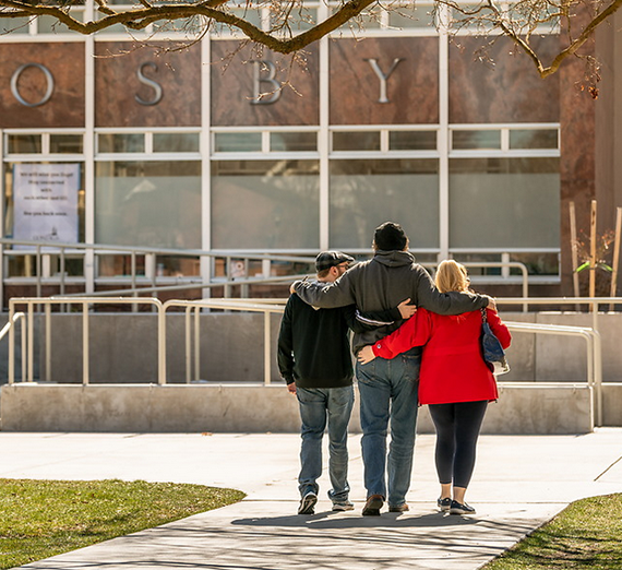 Three students walk away from camera