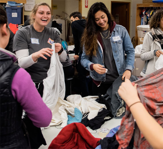 volunteers folding clothes for clothing drive 