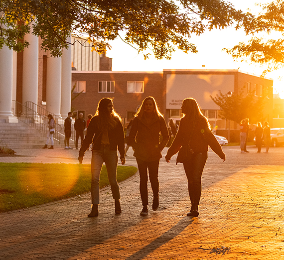 Three students walk through campus.