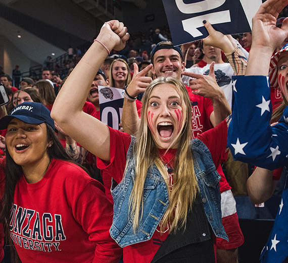 GU Students dressed up in school colors cheering at an athletic event.