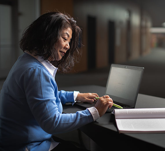 A woman works on her laptop.