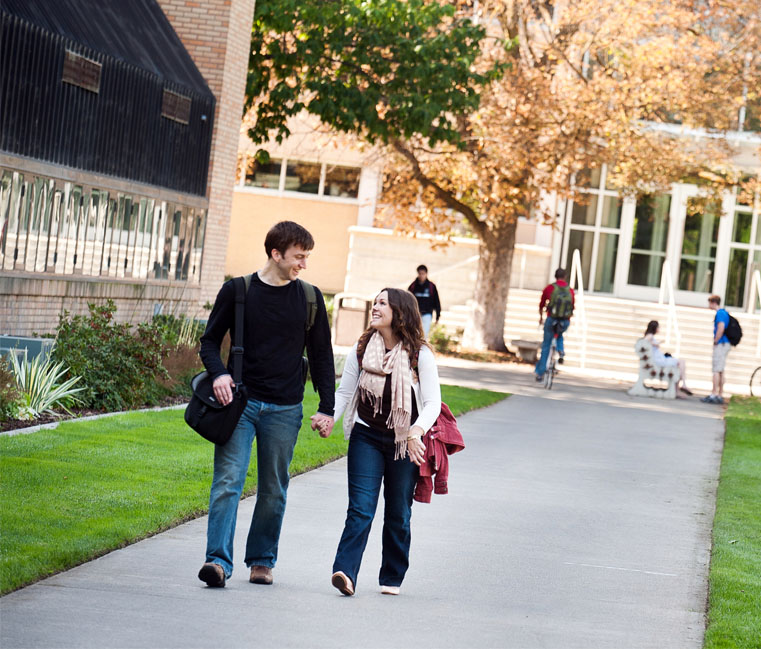 Students walk holding hands in front of Herak 