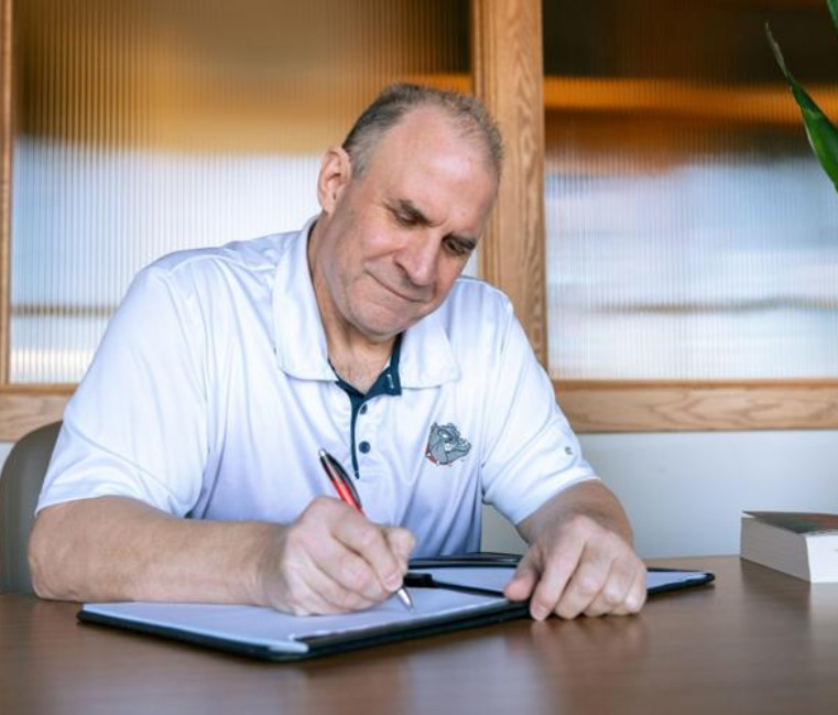 Vito DiMaio at a desk writing. Courtesy of Ash Elliot of the Gonzaga Bulletin