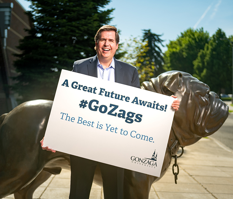 Gonzaga President Thayne McCulloh holds a sign reading "a great future awaits!"