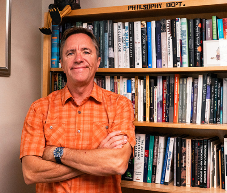 Dr. Kirk Besmer in front of a bookcase