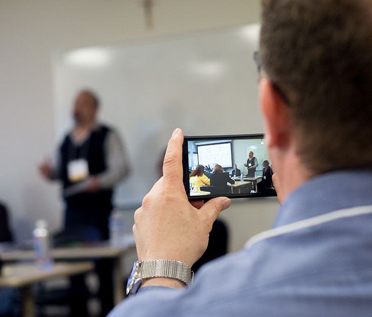 A student is videotaped while giving a presentation.
