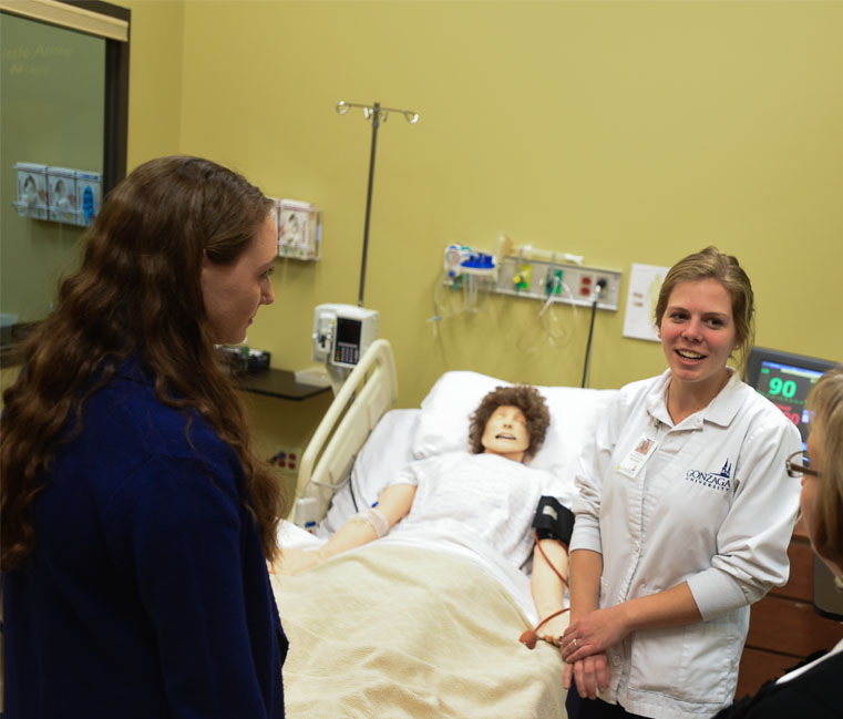 Students care for fake patient during simulation.