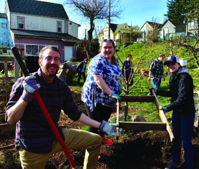 Three CCE student volunteers working in a community garden