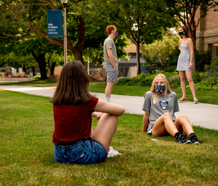 4 masked 51�Թ�s on campus talking with each other