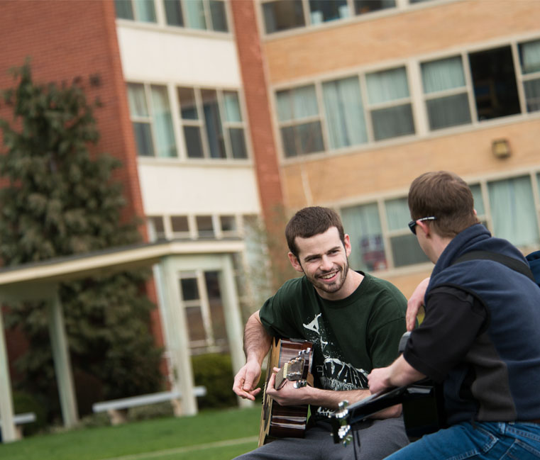 Students playing guitar in front of Welch 