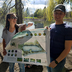 Students hold up plans to launch a floating wetland into the middle of Lake Arthur