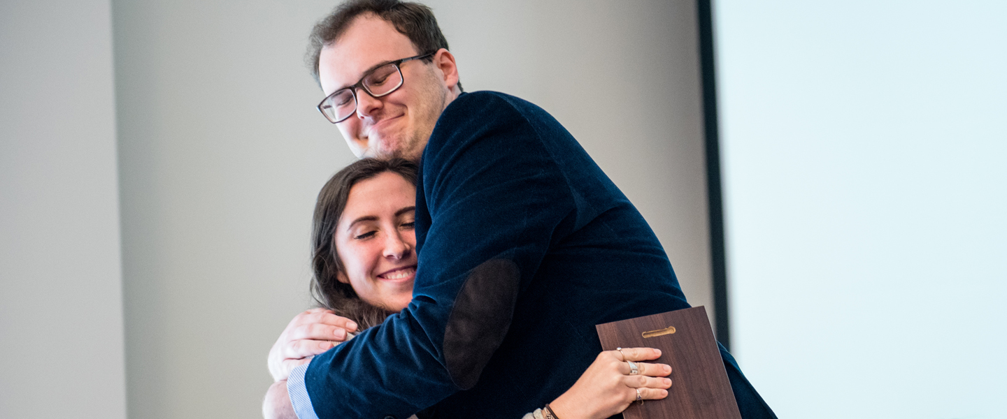 Two students hug after receiving a magis award