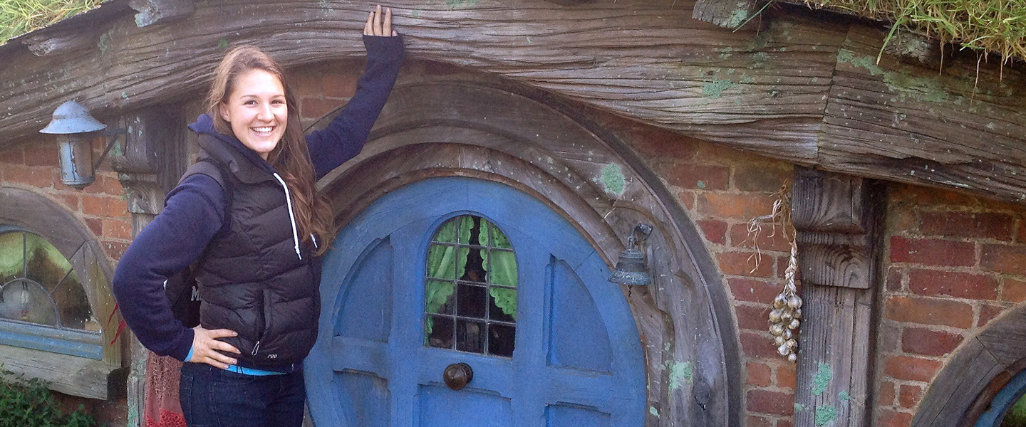 Elizabeth Hassebrock stands outside of a Hobbit hole in New Zealand