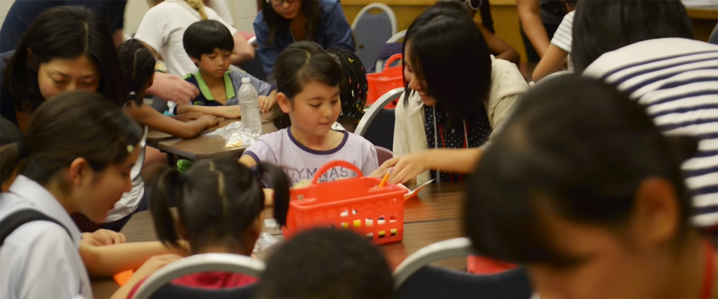 A student teacher works with children at a table