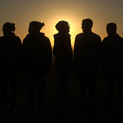 students silhouetted by sunset