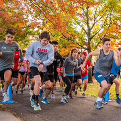 Students begin a 3k race under golden autumn trees