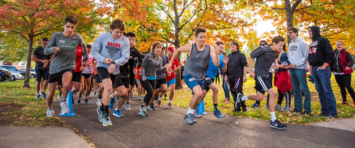 Runners begin the race under autumn colored trees