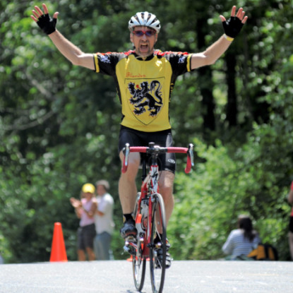 Picture of Jay Stafstrom, Ph.D. riding a bike with his hands in the air.