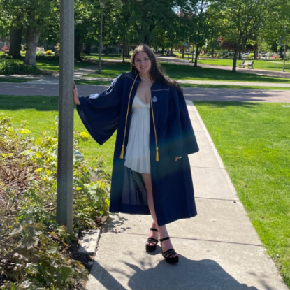 Sydney Baltuck in graduation cap and gown on campus. 