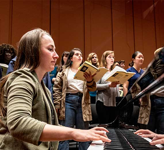 pianist with singers behind her