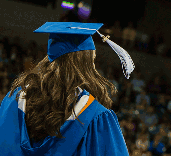 A graduate in cap and gown, with tassel waving, during Commencement 2013.